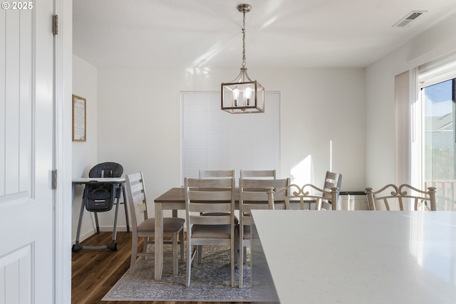 dining room featuring dark hardwood / wood-style flooring and a chandelier