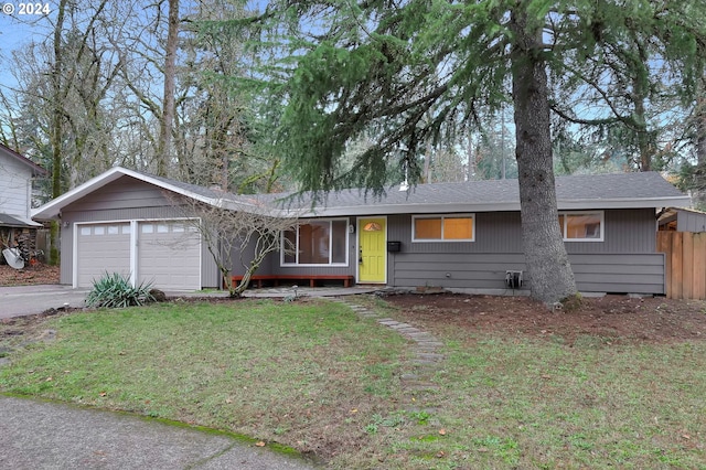 ranch-style home with a garage and a front lawn