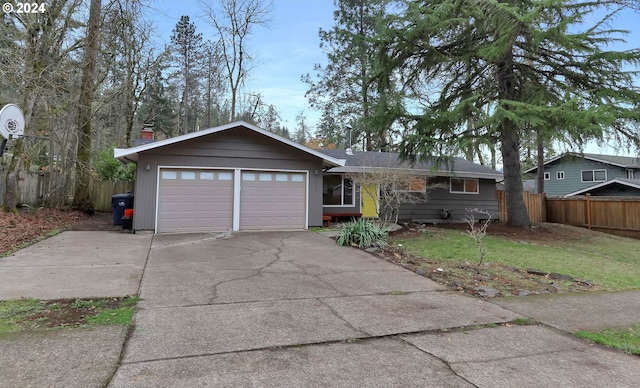 single story home featuring a front lawn and a garage