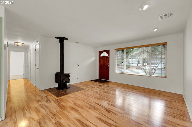 foyer featuring light hardwood / wood-style floors and a wood stove