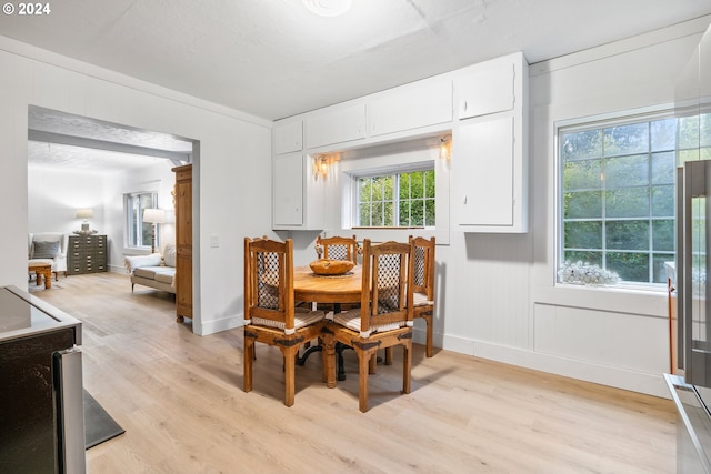 dining room with a healthy amount of sunlight, crown molding, and light hardwood / wood-style flooring