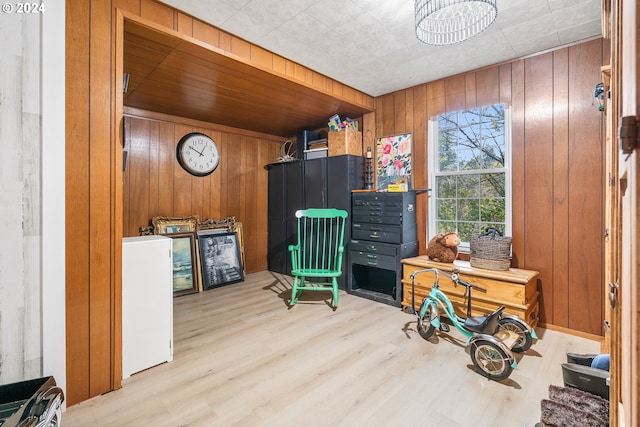 sitting room featuring wood walls and light wood-type flooring