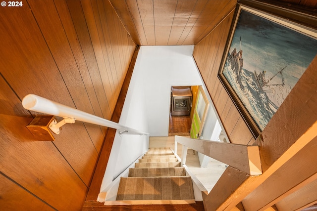 stairs with wood walls and a high ceiling