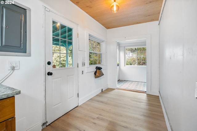 doorway featuring electric panel, light hardwood / wood-style floors, and wood ceiling