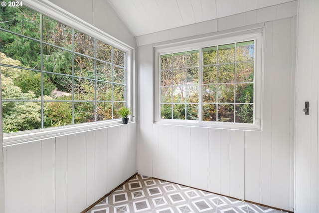 unfurnished sunroom featuring vaulted ceiling