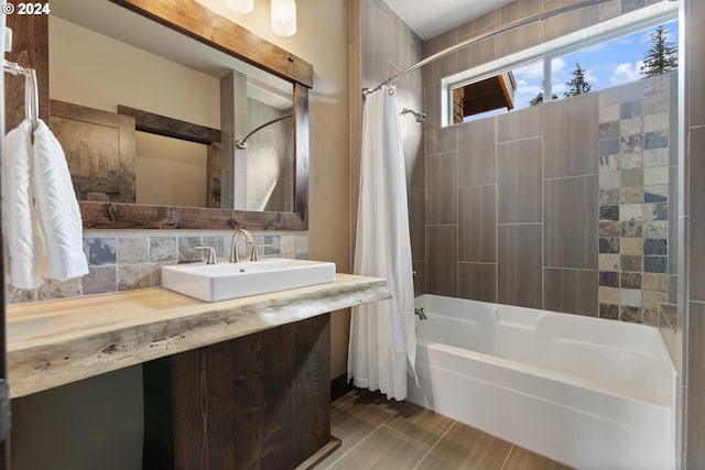 bathroom featuring decorative backsplash, sink, shower / bathtub combination with curtain, and tile walls