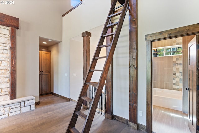 stairway with hardwood / wood-style flooring and ornate columns