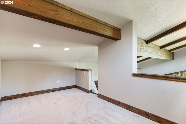 interior space with carpet and vaulted ceiling with beams