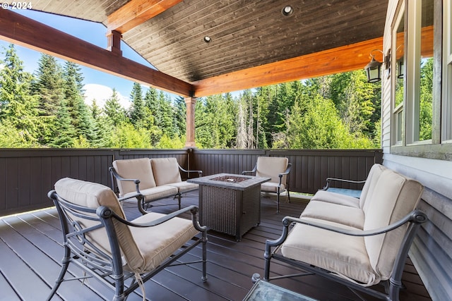 wooden terrace with an outdoor living space with a fire pit