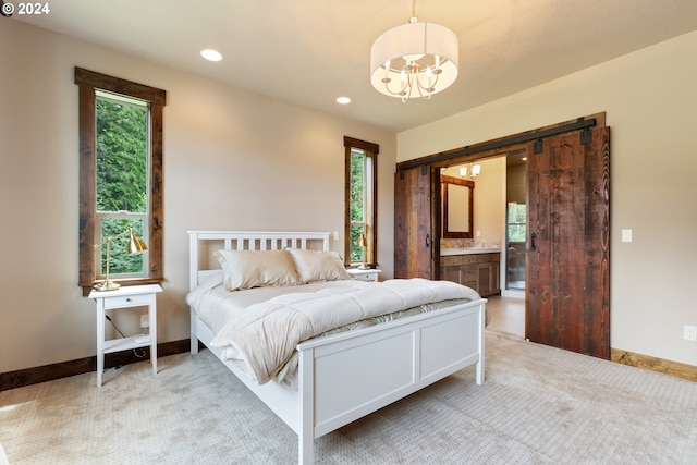 carpeted bedroom featuring multiple windows, ensuite bath, and an inviting chandelier