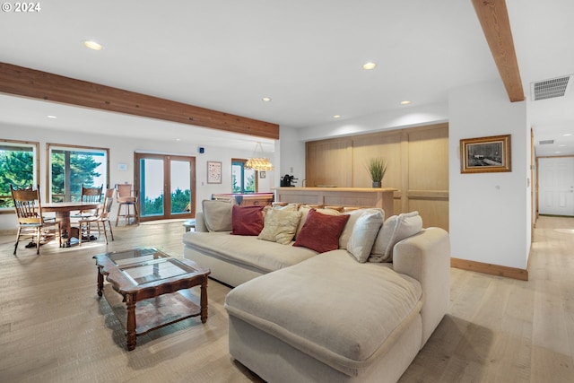 79274 Ray Brown Rd, Arch Cape, OR 97102 - living room with beamed ceiling, a notable chandelier, french doors, and light hardwood / wood-style flooring