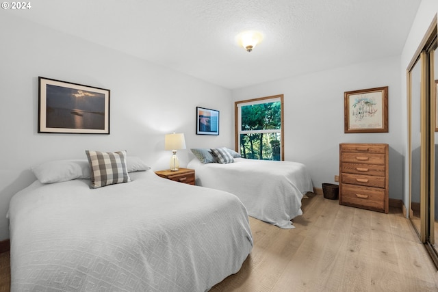 79274 Ray Brown Rd, Arch Cape, OR 97102 - bedroom with a textured ceiling, light hardwood / wood-style floors, and a closet