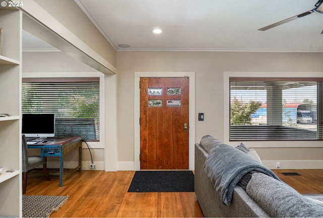 entrance foyer featuring hardwood / wood-style flooring, ceiling fan, and ornamental molding