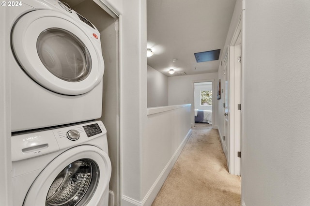 clothes washing area with light colored carpet and stacked washer and dryer