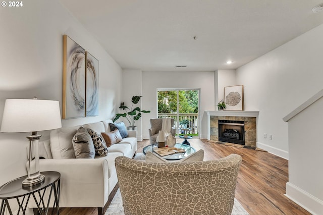 living room featuring hardwood / wood-style floors and a tile fireplace