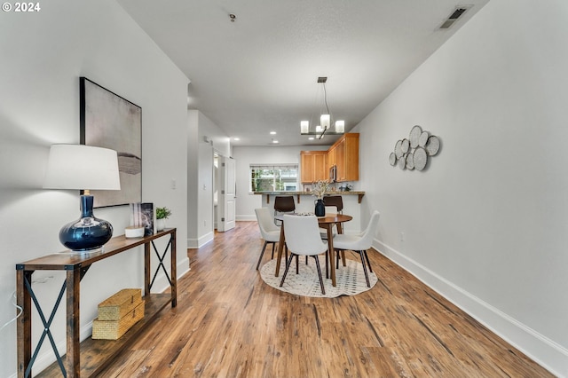 dining space featuring an inviting chandelier and light hardwood / wood-style floors