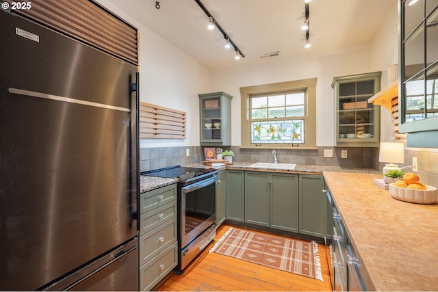 kitchen with stainless steel appliances, a healthy amount of sunlight, sink, and backsplash