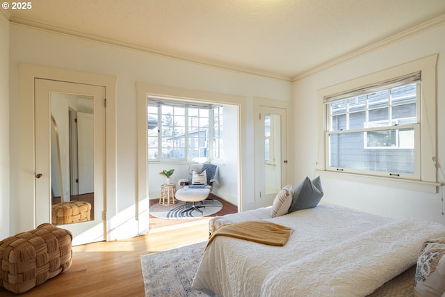 bedroom with ornamental molding and light hardwood / wood-style floors