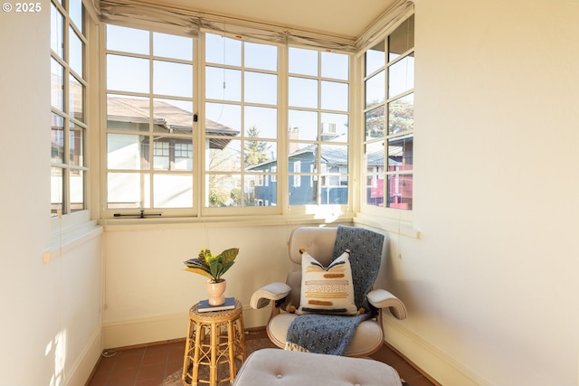 living area featuring a healthy amount of sunlight and dark tile patterned flooring