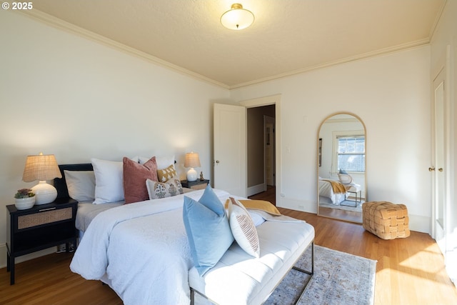 bedroom with wood-type flooring and ornamental molding