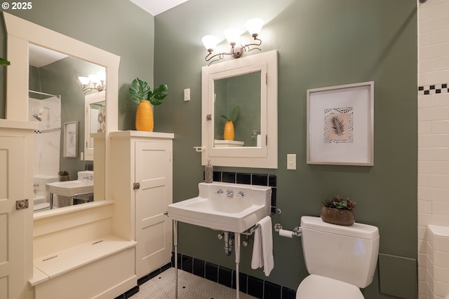 bathroom featuring walk in shower, toilet, and sink