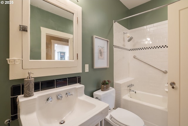 full bathroom with tiled shower / bath, sink, and toilet