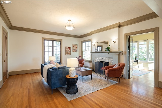 living room with a tile fireplace, a textured ceiling, and light wood-type flooring