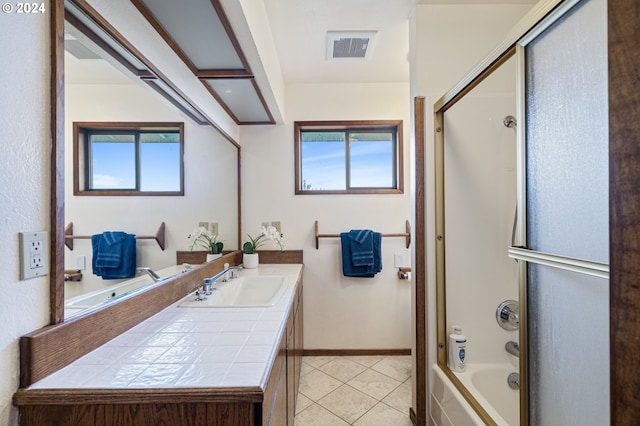 bathroom with vanity, combined bath / shower with glass door, and tile patterned flooring