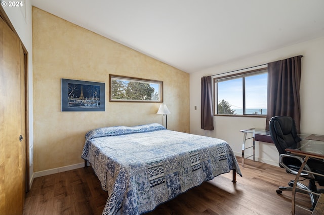 bedroom with vaulted ceiling and wood-type flooring