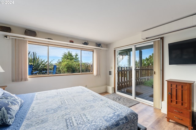 bedroom featuring light hardwood / wood-style floors, multiple windows, and access to exterior