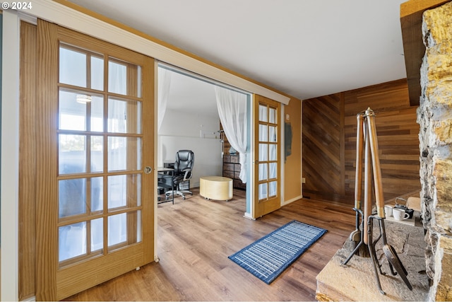 doorway to outside with french doors, hardwood / wood-style flooring, and wood walls