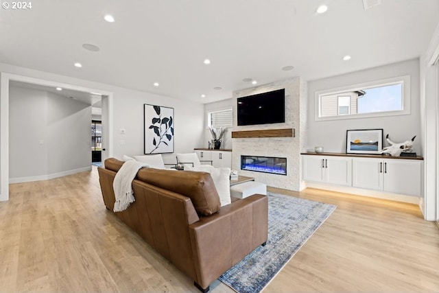 living room featuring light hardwood / wood-style floors and a large fireplace