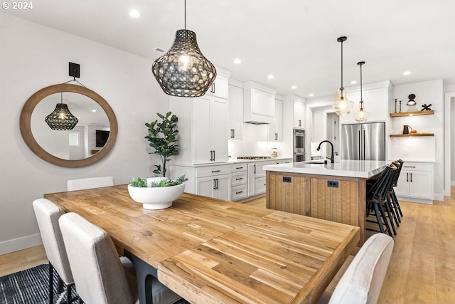 dining room with sink and light wood-type flooring