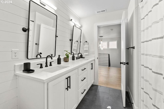 bathroom with wood-type flooring and dual bowl vanity