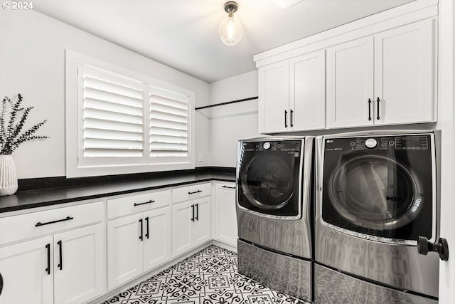 laundry room with washer and clothes dryer, cabinets, and light tile floors