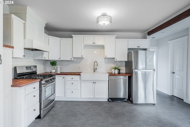 kitchen with stainless steel appliances, white cabinetry, tasteful backsplash, and sink