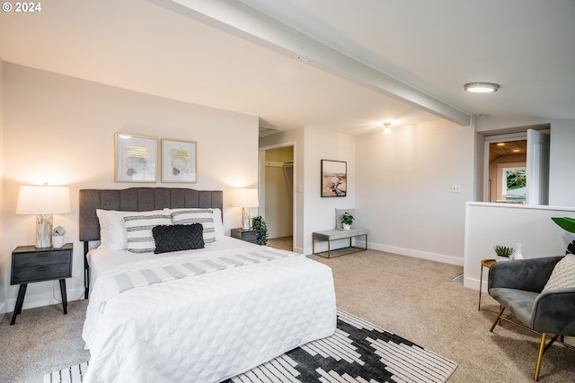 carpeted bedroom with beam ceiling and a closet