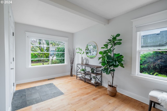 interior space featuring beamed ceiling and hardwood / wood-style flooring