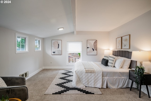 bedroom with multiple windows, lofted ceiling with beams, and light colored carpet