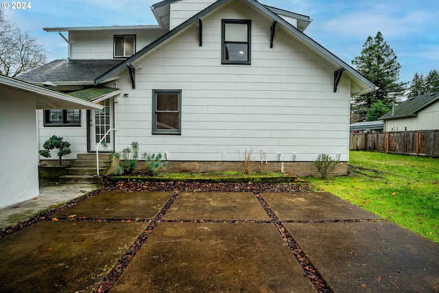 back of house featuring a lawn and a patio area