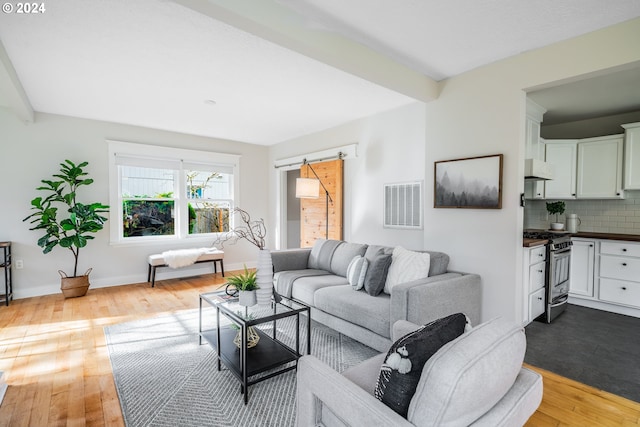 living room featuring light wood-type flooring and a barn door