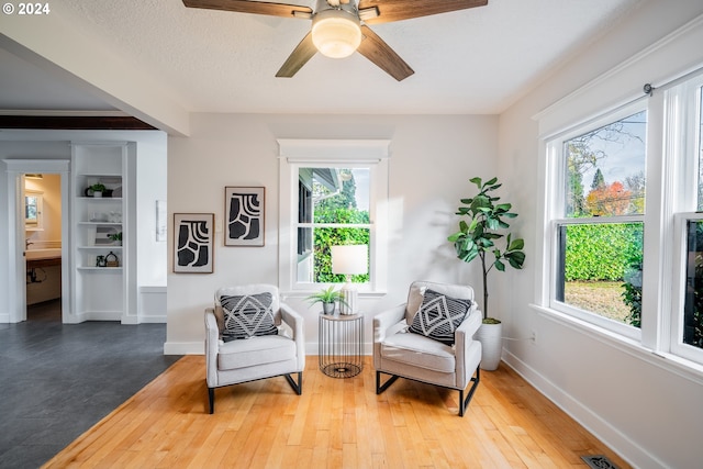 sitting room with hardwood / wood-style floors, a textured ceiling, and ceiling fan