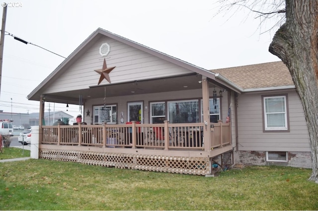 back of house with a lawn and covered porch