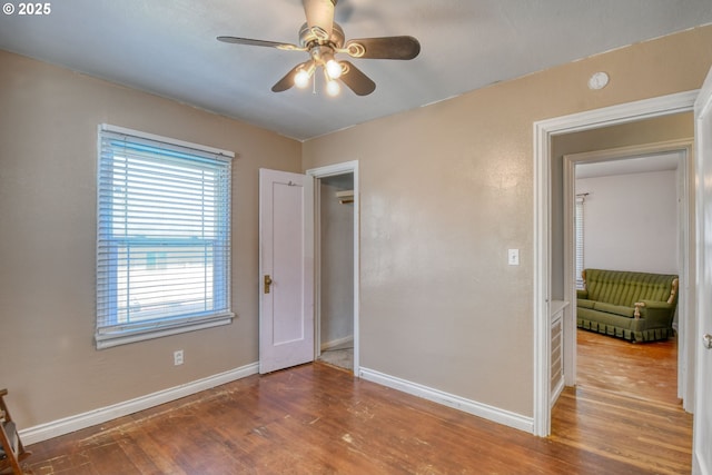 unfurnished bedroom featuring baseboards, ceiling fan, and wood finished floors