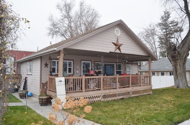 rear view of property featuring a lawn and a porch