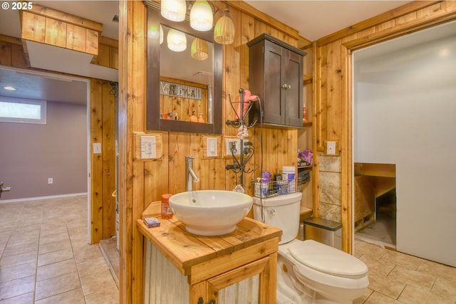 bathroom with vanity, tile patterned floors, wooden walls, and toilet