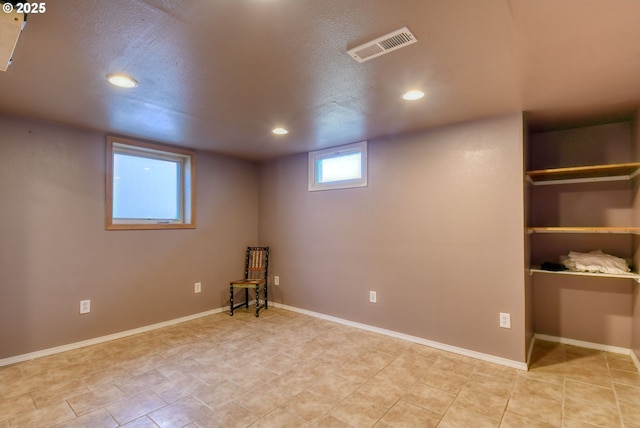 basement with baseboards, recessed lighting, light tile patterned flooring, and visible vents