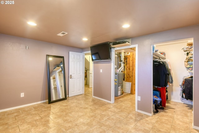 bedroom with a walk in closet, visible vents, baseboards, a closet, and recessed lighting