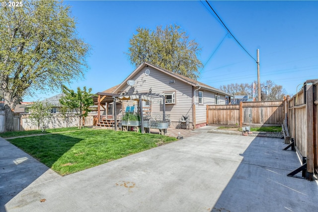 back of property featuring a fenced backyard, a yard, and a patio area