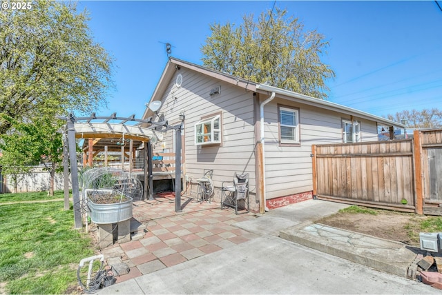 rear view of property with a yard, a pergola, fence, and a patio